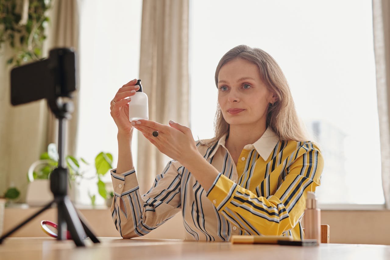 Woman in Yellow and Black Long Sleeves Holding a Glass Pump Bottle