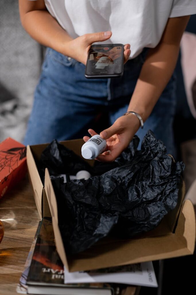 pexels-photo-7801878-1 Woman Taking out a Bottle out of a Parcel and Taking Photo with her Smartphone